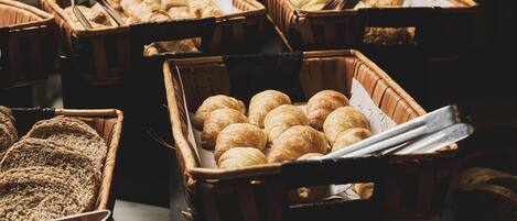 Multiple wicker baskets filled with various baked goods, including bread and pastries.