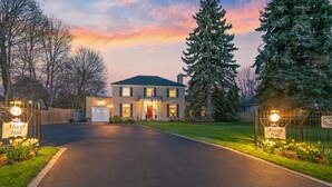 A two-story house with a well-maintained lawn and a driveway leading to the entrance. - Abacot Hall Bed & Breakfast (Niagara-on-the-Lake)