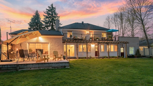 A two-story house with a covered patio area, a balcony, and a well-maintained lawn. - Abacot Hall Bed & Breakfast (Niagara-on-the-Lake)