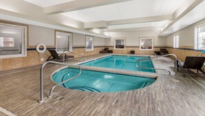 Une piscine intérieure avec des couloirs clairement délimités, des rampes de sécurité et un sol carrelé.