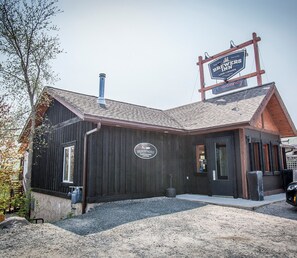 A rustic building with a sign indicating a 'BROKEN PADDLE COFFEE ROASTY & KITCHEN' and a 'BREWERS INN' sign above.