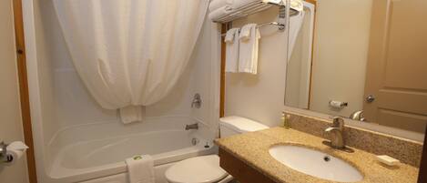 A bathroom with a bathtub, toilet, and sink.