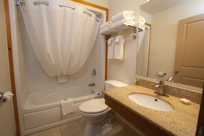 A bathroom with a bathtub, toilet, and sink.
