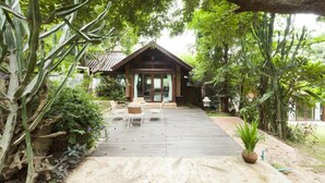 A wooden deck leading to a building with a sloped roof, surrounded by lush greenery. - Viva Chiang Mai (Chiang Mai)
