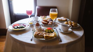 Une table de petit-déjeuner avec divers plats, notamment des crêpes, des œufs et des fruits.
