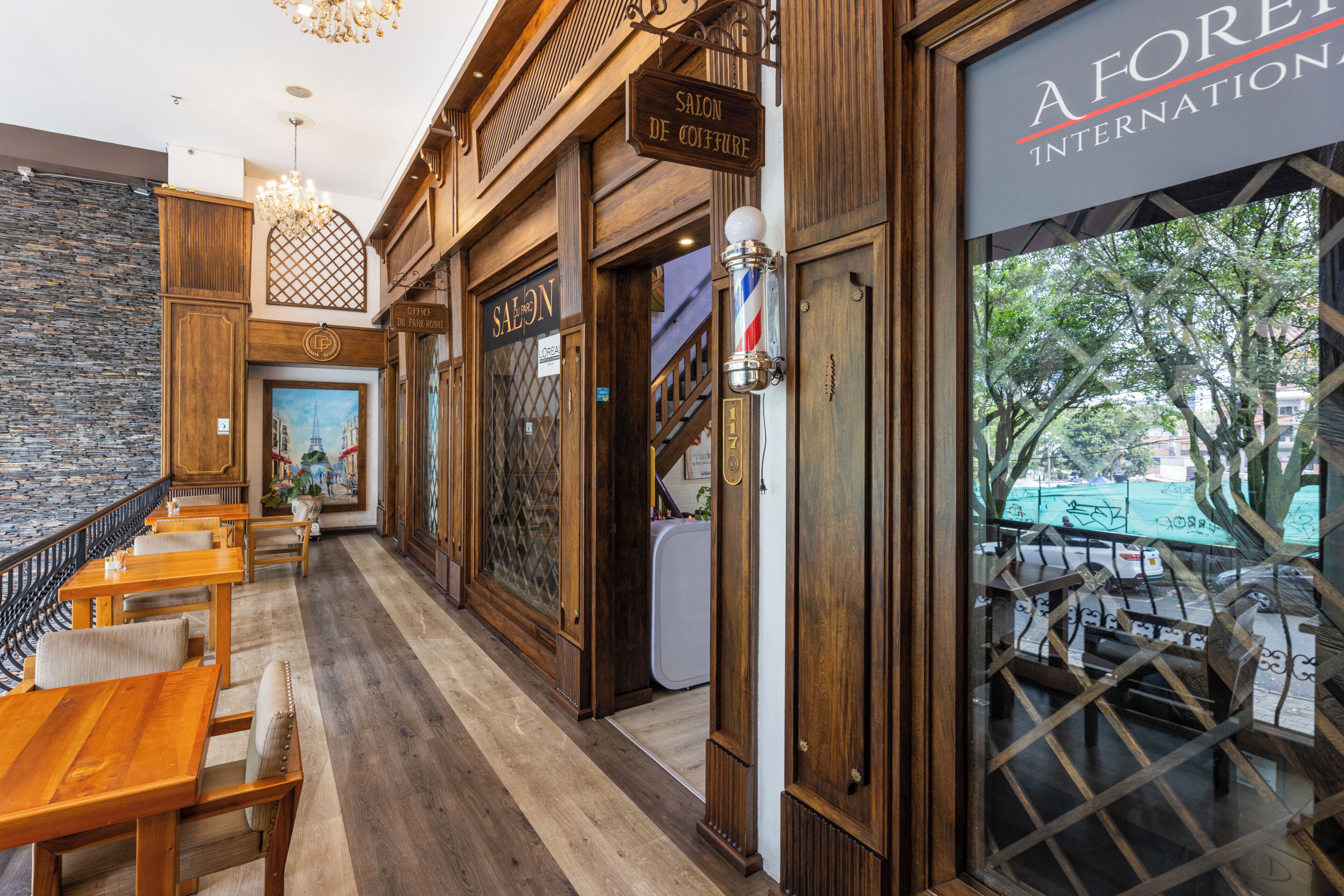 A restaurant with wooden interiors, a bar, and a view of the outside.