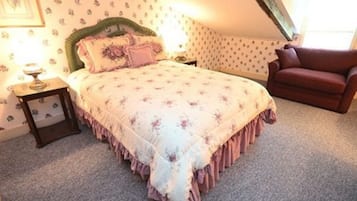 Une chambre à coucher avec un lit, une table de chevet, une chaise et une fenêtre.