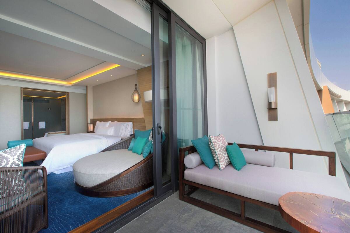 Une chambre d’hôtel moderne avec deux lits, un canapé et une petite table.