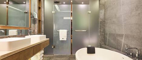 A modern bathroom with a large freestanding bathtub, a double sink vanity, and a glass shower enclosure.