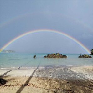 A beach with clear water, a rainbow, and rocky outcrops. - House Jardin Del Caribe (Las Terrenas)