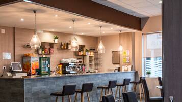 Un caffè con un'area bar, posti a sedere e una macchina per il caffè.
