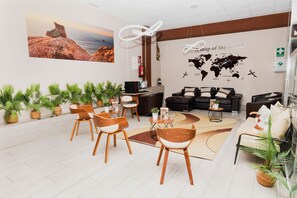 Un vestíbulo moderno con un mapa mundial, zona de estar y plantas en macetas.