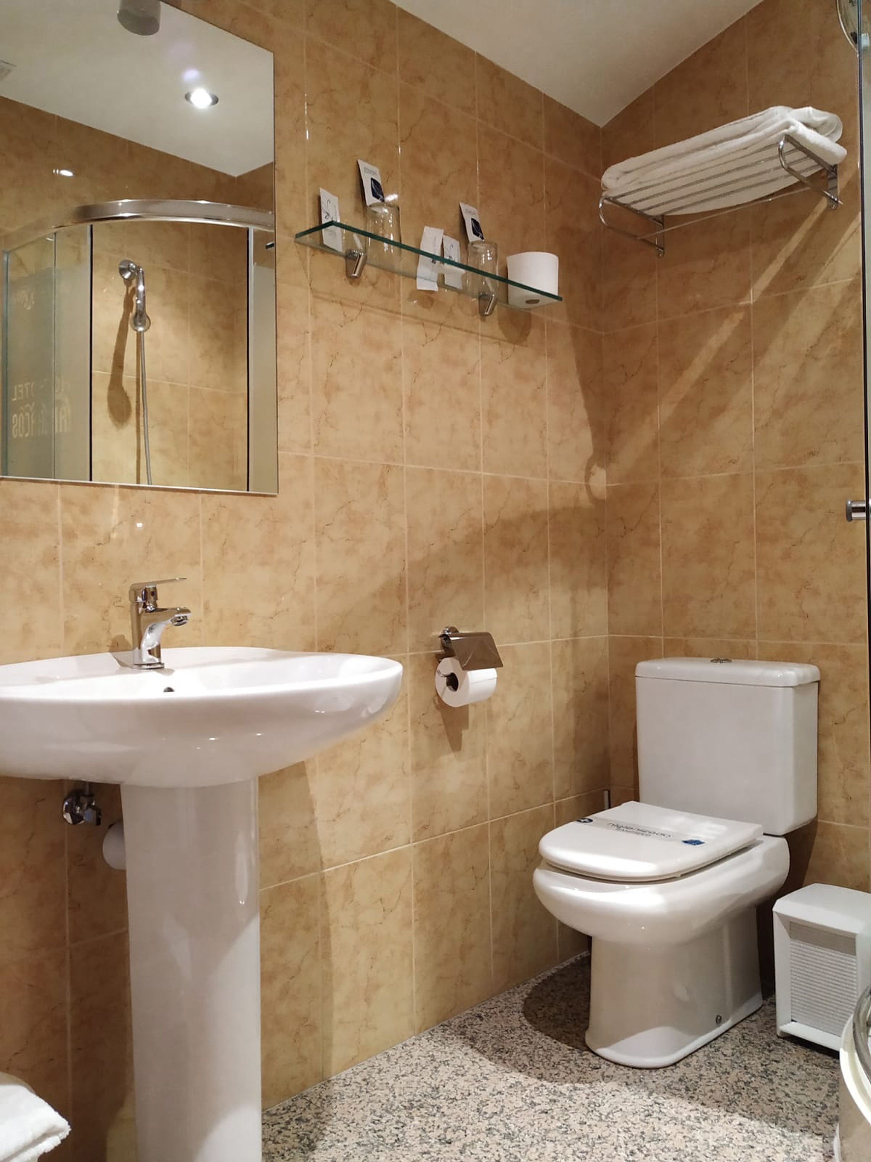A bathroom with a sink, toilet, and shower.