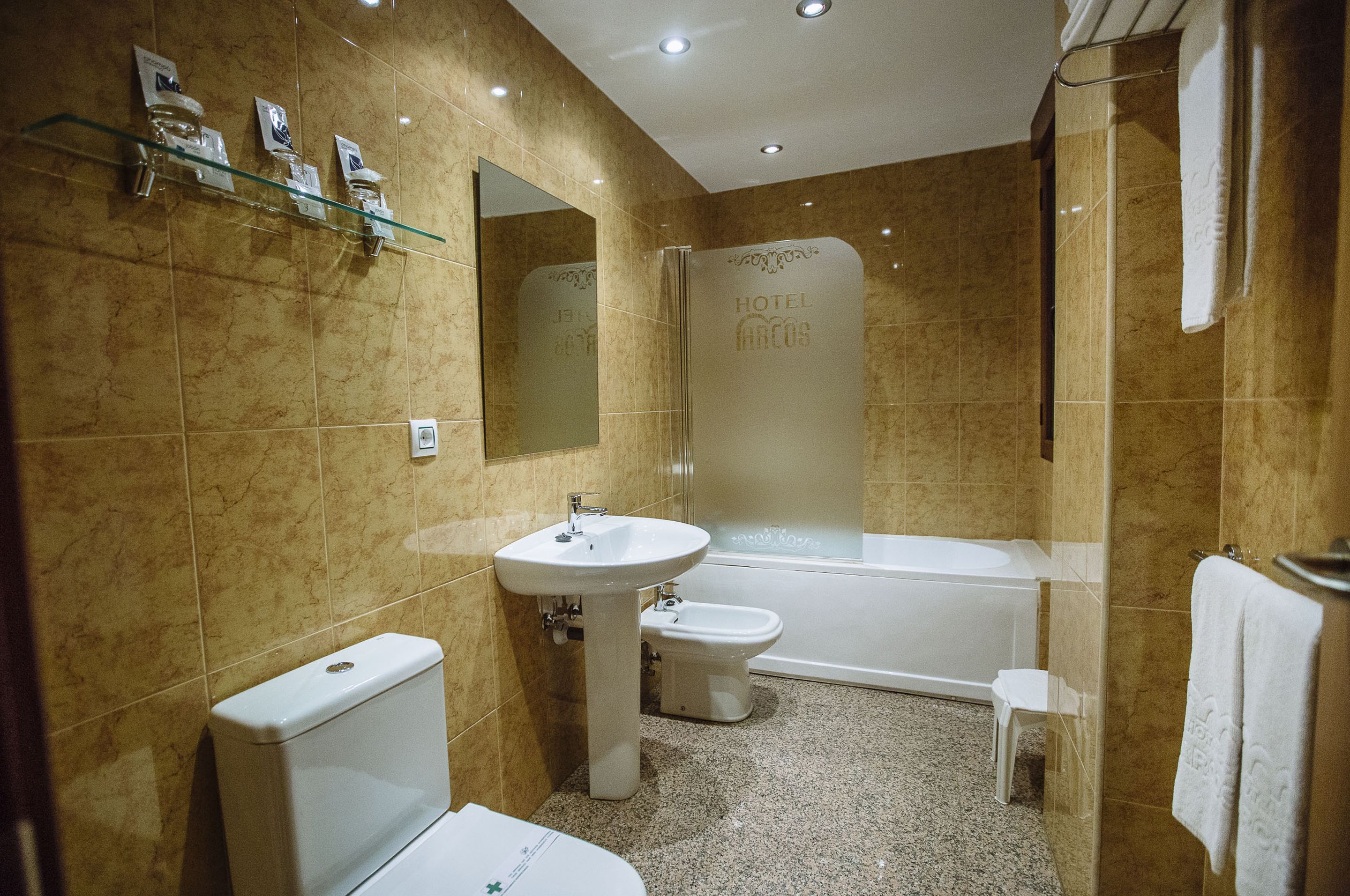 Un baño con inodoro, bidé, lavabo y bañera.