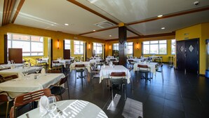 A spacious dining area with multiple tables and chairs, large windows, and a clean, modern design. - El Paso Honroso (Hospital de Orbigo)