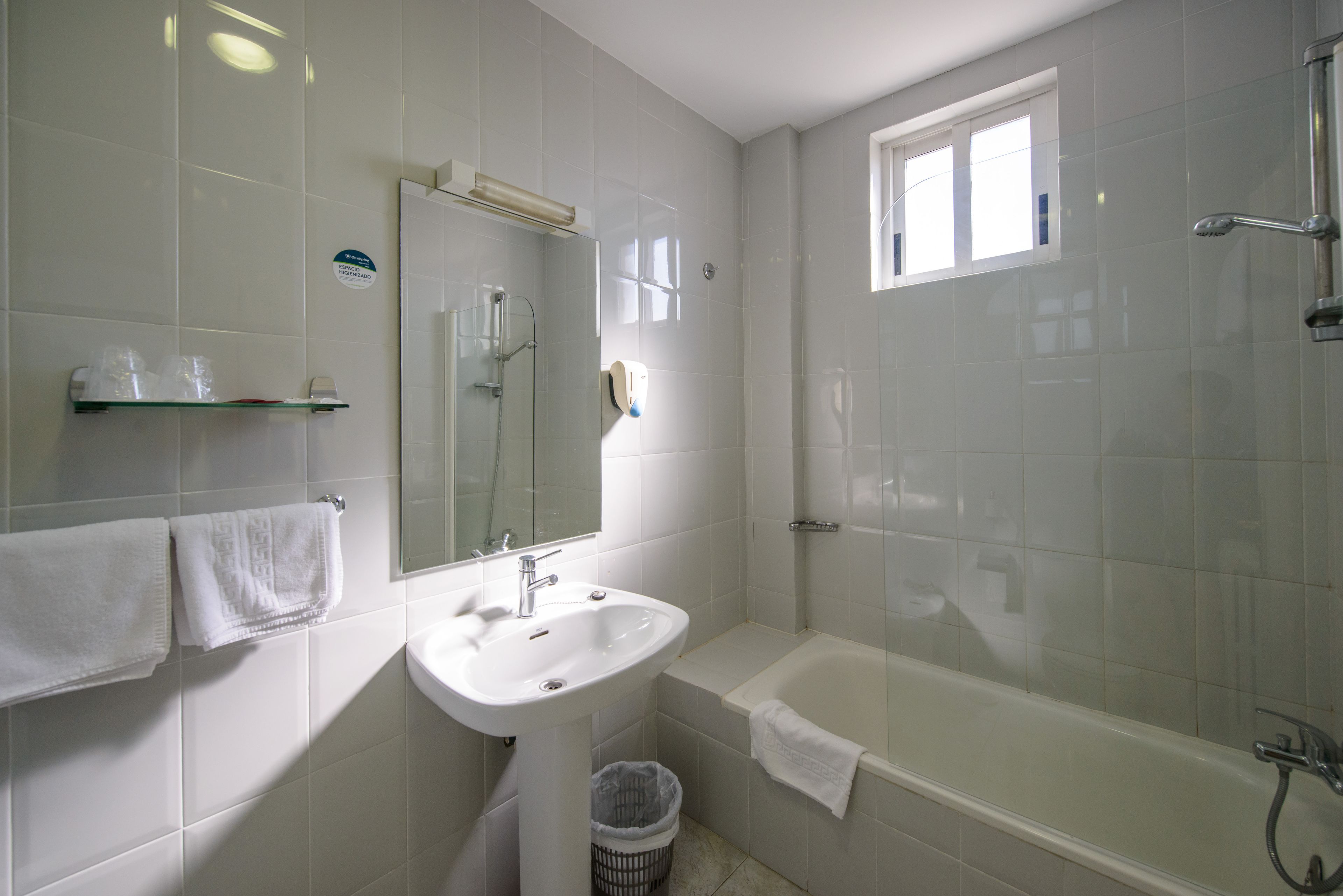 Un baño con lavabo, espejo y bañera.