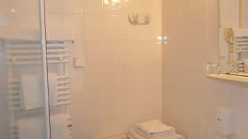 A bathroom with white tiles, a sink, a mirror, and a towel rack.