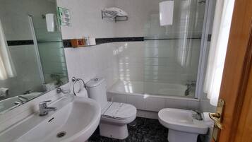 A bathroom with a bathtub, a toilet, and a sink.
