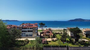 Un área residencial costera con edificios, cielo azul despejado y vista al mar.