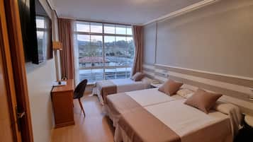 Driepersoonskamer | Een minibar, een kluis op de kamer, een bureau, verduisterende gordijnen