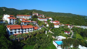 Een resort met meerdere gebouwen, een zwembad en weelderige groene begroeiing.