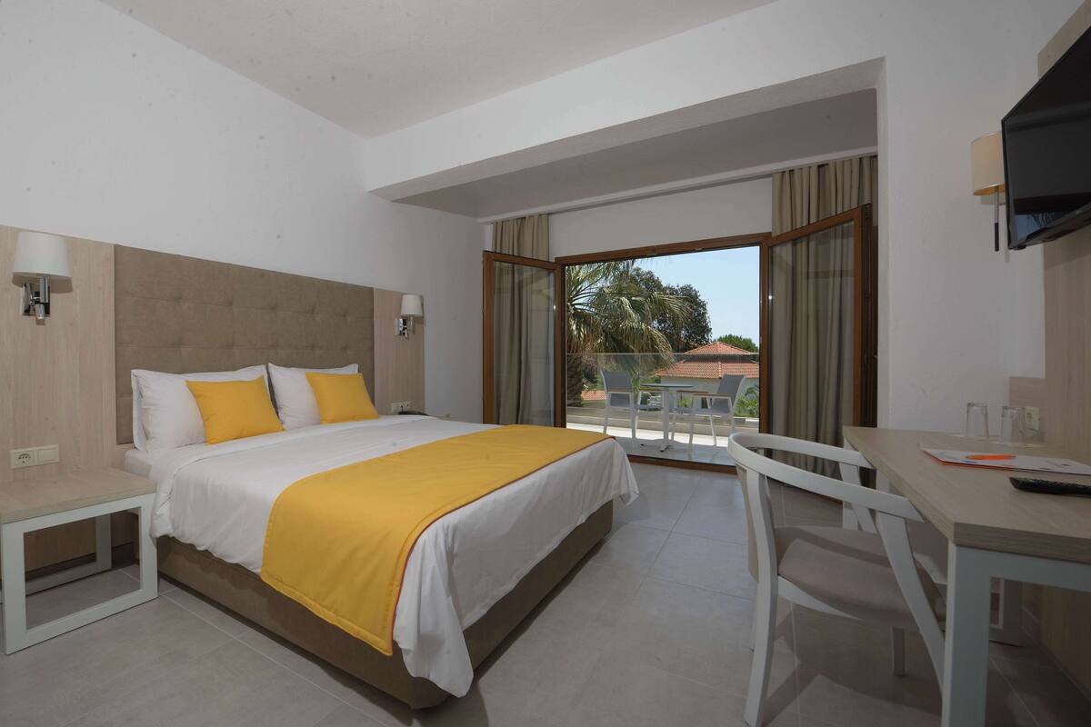 Een hotelkamer met een bed, een bureau en een stoel.