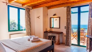 Un dormitorio con cama, escritorio y vistas al exterior.