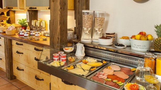 Un buffet proposant une variété de plats, notamment des fruits, des fromages et des viandes.