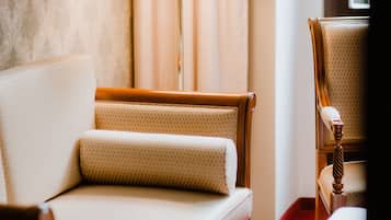 A hotel room with a sofa, a table, and a lamp.