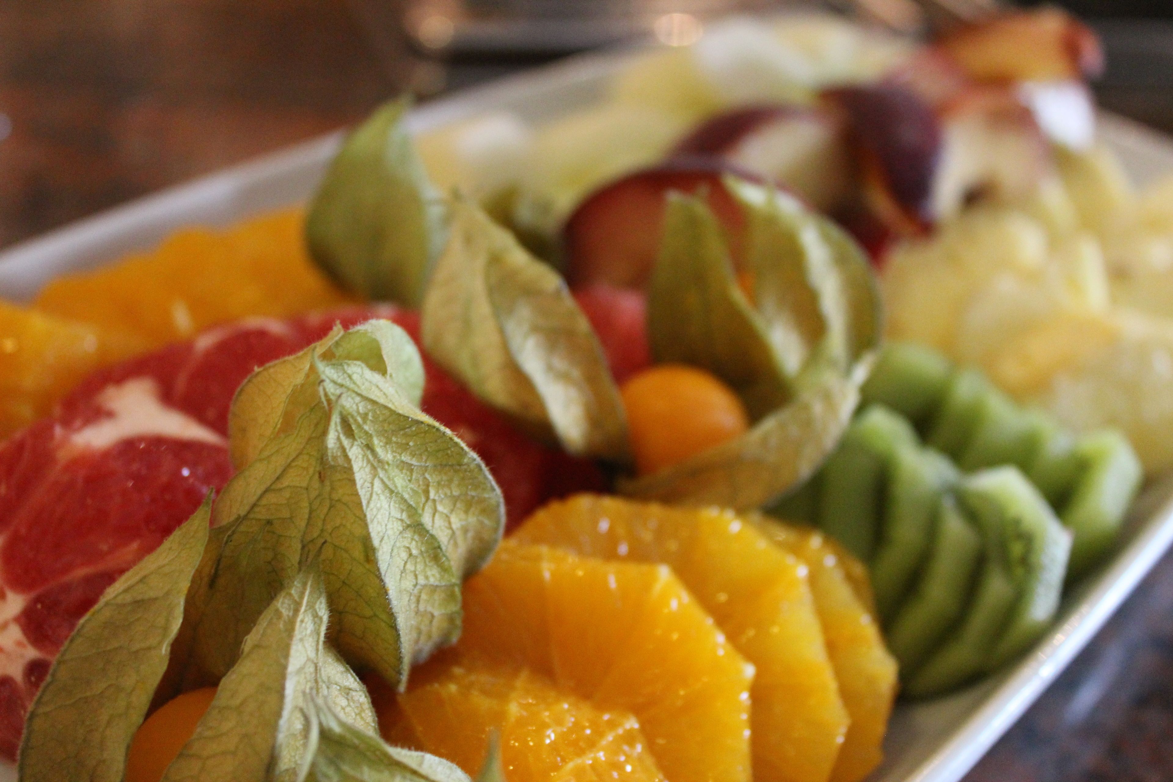 Een fruitschaal met verschillende soorten fruit en bladeren.