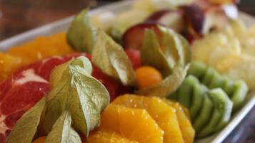 Een fruitschaal met verschillende soorten fruit en bladeren.