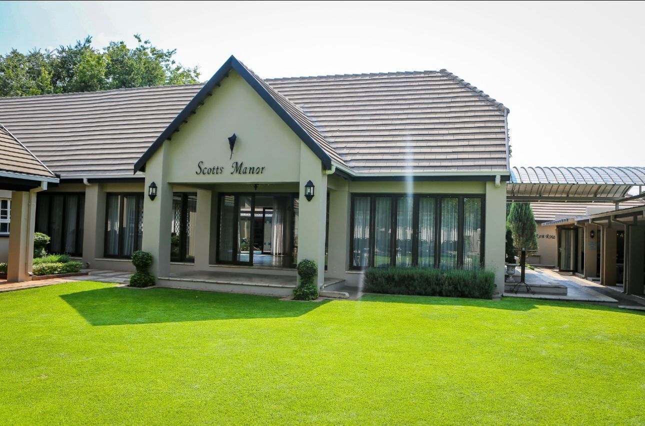 En byggnad som heter ”Scotts Manor” med en välskött gräsmatta framför.