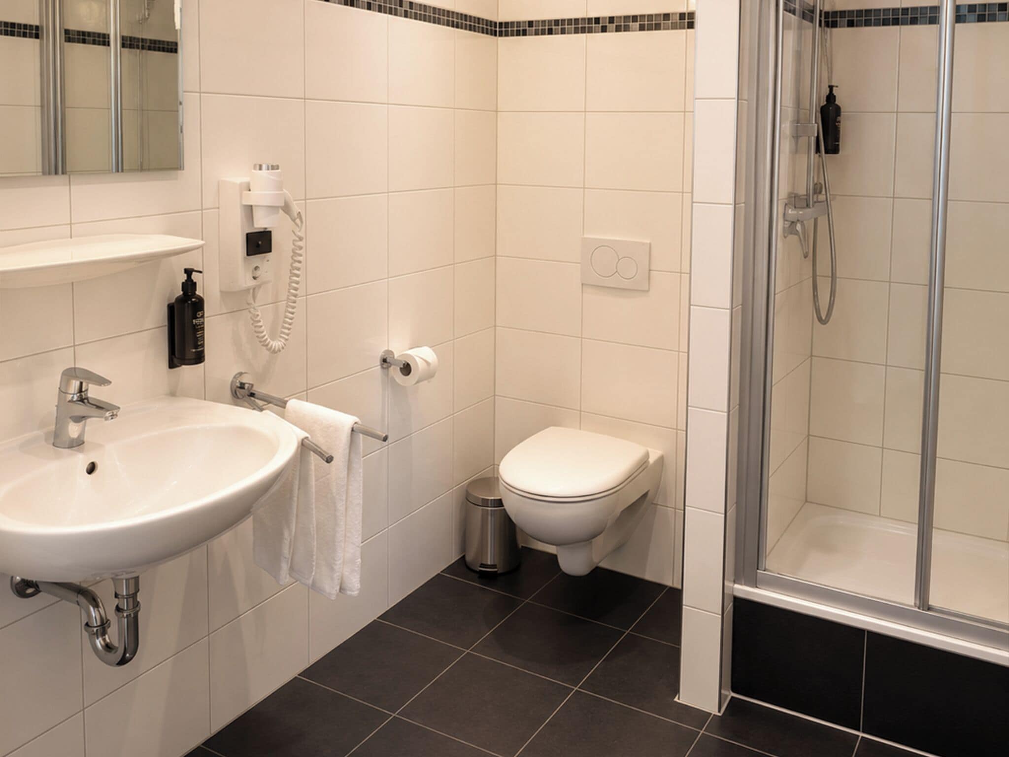 A bathroom with a sink, toilet, and shower.