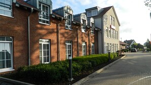 Una hilera de edificios modernos de ladrillo con grandes ventanales y una calle pavimentada.