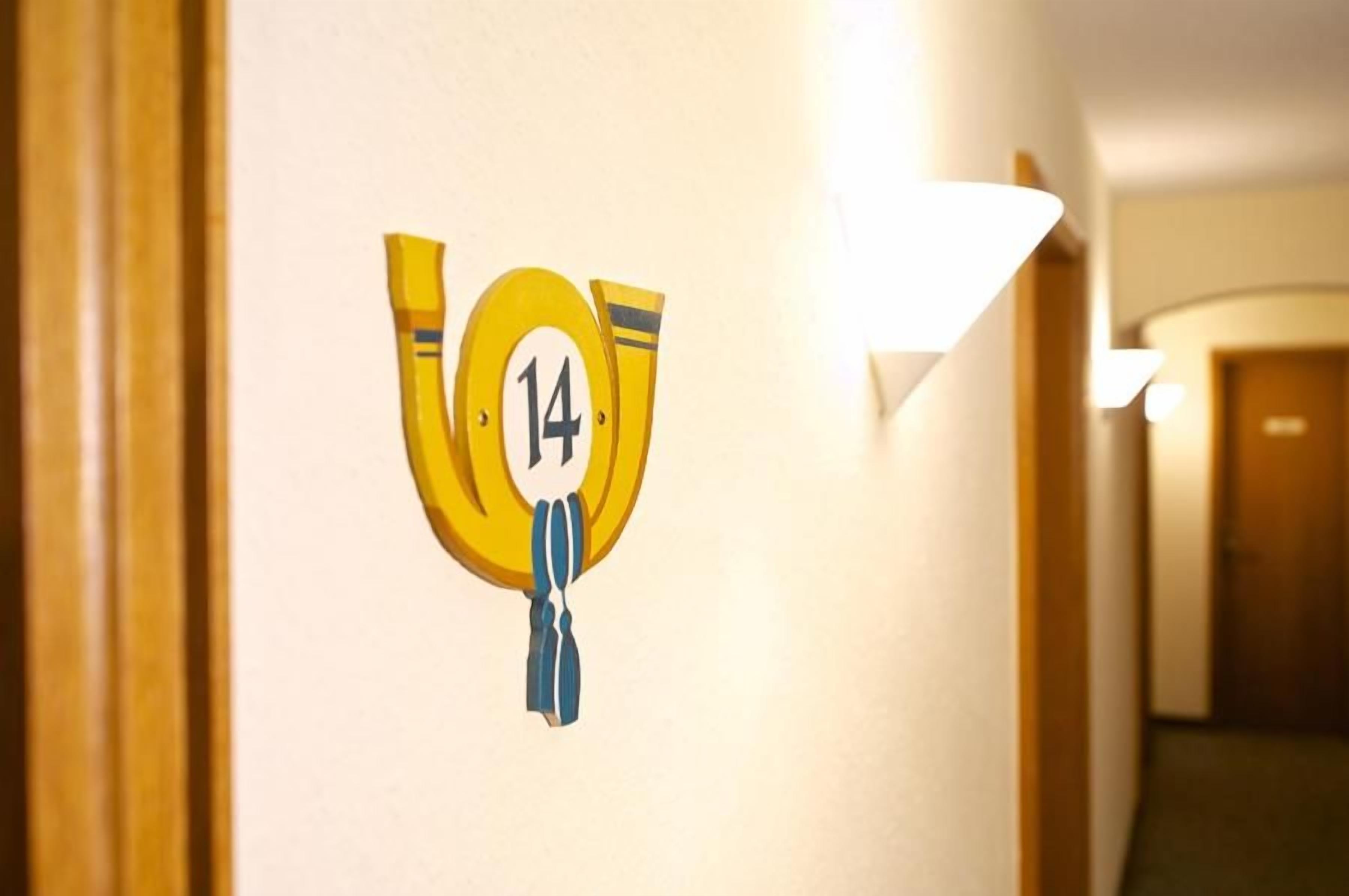 A hallway with a wall-mounted sign displaying the number 14.