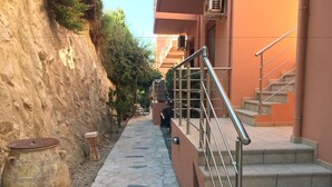 Un chemin de pierre menant à un escalier doté de rampes en métal.