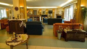 Um hall amplo com área de bar, assentos confortáveis e lareira.