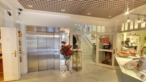 A hotel lobby with a reception desk, a staircase, and a vending machine. - Hotel Diamant (Wedel)