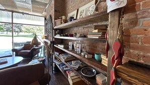 A cozy interior with a brick wall, wooden shelves, and a leather chair. - William Watson Hotel (Pittsfield)