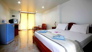 A hotel room with a bed, a desk with a computer, a chair, and a television. - Lotus Friendly Hotel (Koh Samui)