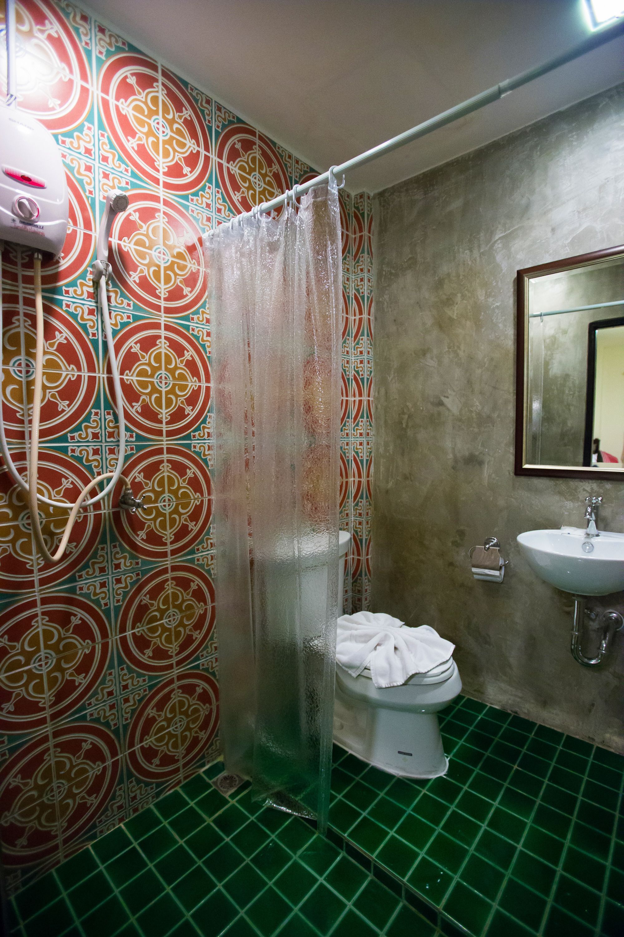 A bathroom with a shower curtain, a toilet, a sink, and a mirror.