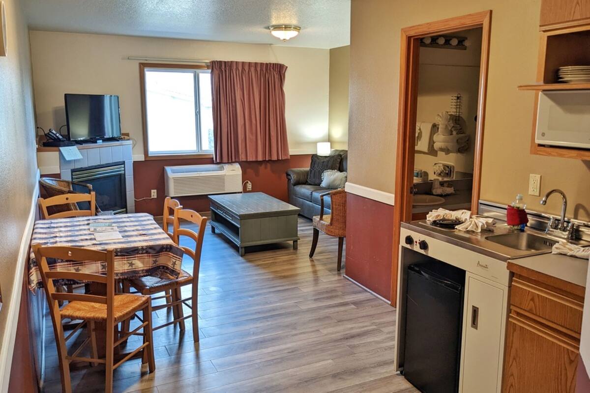 A compact living space with a dining area, kitchenette, and a sofa.