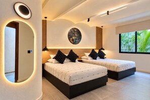 A modern hotel room with two beds, a large mirror, a round artwork on the wall, and a window with a view of greenery. - Casa Los Cantaros Hotel Boutique (Oaxaca)