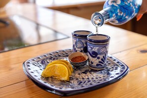 Un plateau avec deux tasses en céramique, un bol d’épices et une tranche de citron, le tout posé sur une table en bois.