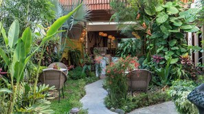 Un jardin agrémenté de meubles en osier, d’un sentier et de différentes plantes.