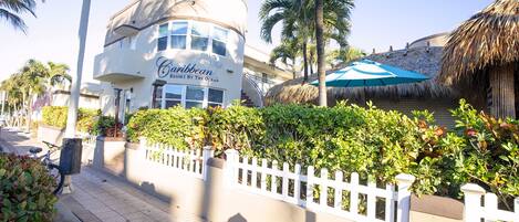 A Caribbean resort building with a white facade and a sign that reads "Caribbean Resort of the Ocean."