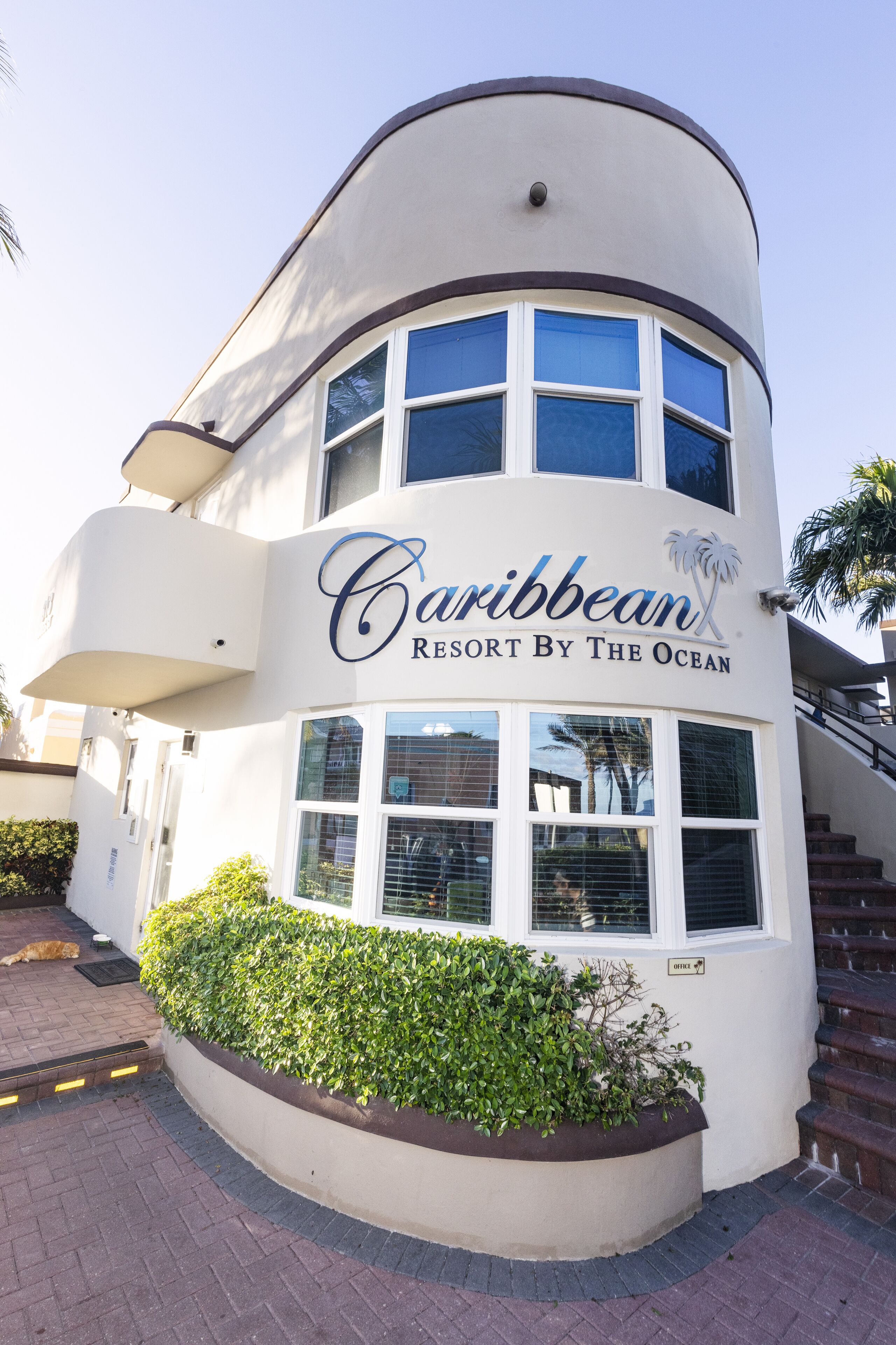 Un edificio de dos pisos con un cartel que dice 'Caribbean Resort By The Ocean'.