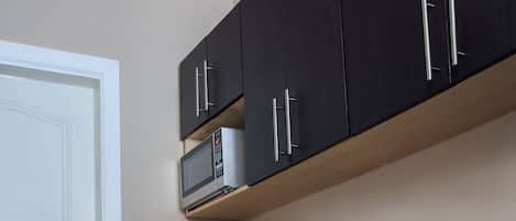 A kitchen with dark cabinets, a microwave, and a stove.