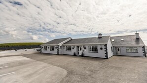 A large, single-story building with a flat roof and a parking lot in front.