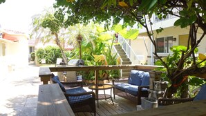 An outdoor patio with wicker furniture, a grill, and a water feature.